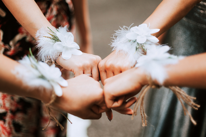 Bridesmaid girls showing flowers on her wrists, girls power