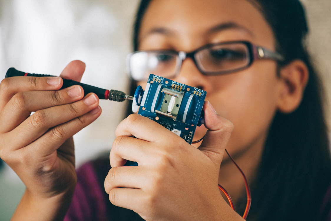 Young girl building a robot